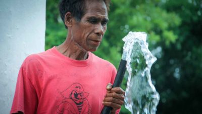 A man holding a pipe with water flowing from its opening
