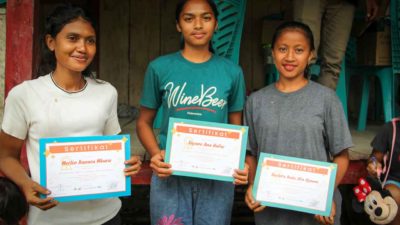 Three primary medical care trainees holding their certificates