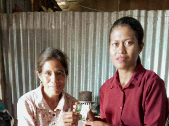 A health agent from Kawan Sehat is providing medical care to a patient in a remote village.