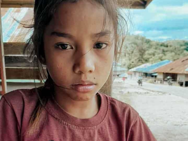 A health agent from Kawan Sehat is providing medical care to a patient in a remote village.