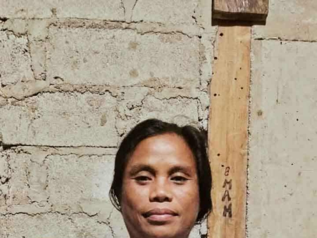 A health agent from Kawan Sehat is providing medical care to a patient in a remote village.