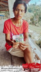 A health agent from Kawan Sehat is providing medical care to a patient in a remote village.