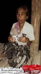 A health agent from Kawan Sehat is providing medical care to a patient in a remote village.