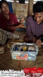 A health agent from Kawan Sehat is providing medical care to a patient in a remote village.