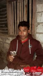 A health agent from Kawan Sehat is providing medical care to a patient in a remote village.