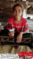 A health agent from Kawan Sehat is providing medical care to a patient in a remote village.