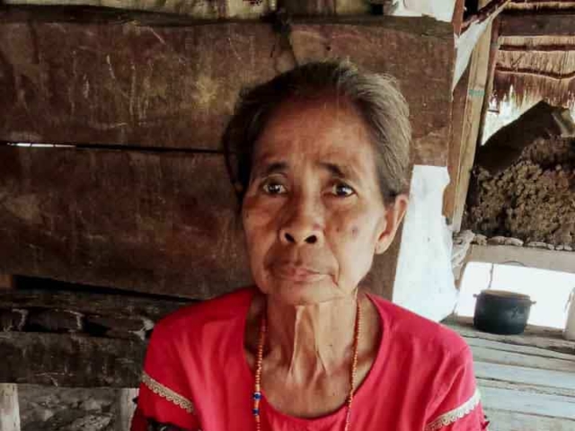 A health agent from Kawan Sehat is providing medical care to a patient in a remote village.