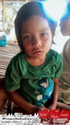 A health agent from Kawan Sehat is providing medical care to a patient in a remote village.