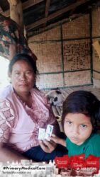 A health agent from Kawan Sehat is providing medical care to a patient in a remote village.