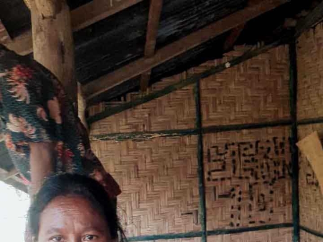 A health agent from Kawan Sehat is providing medical care to a patient in a remote village.