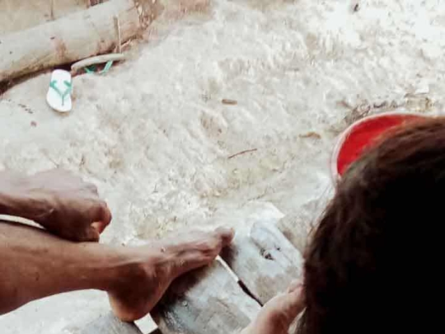 A health agent from Kawan Sehat is providing medical care to a patient in a remote village.