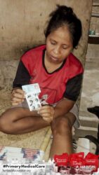 A health agent from Kawan Sehat is providing medical care to a patient in a remote village.