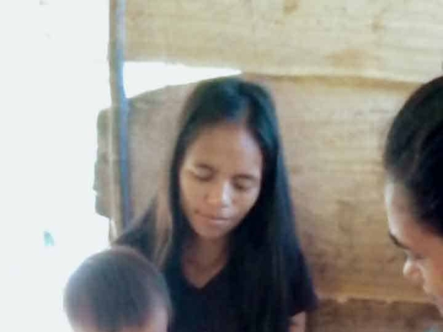 A health agent from Kawan Sehat is providing medical care to a patient in a remote village.