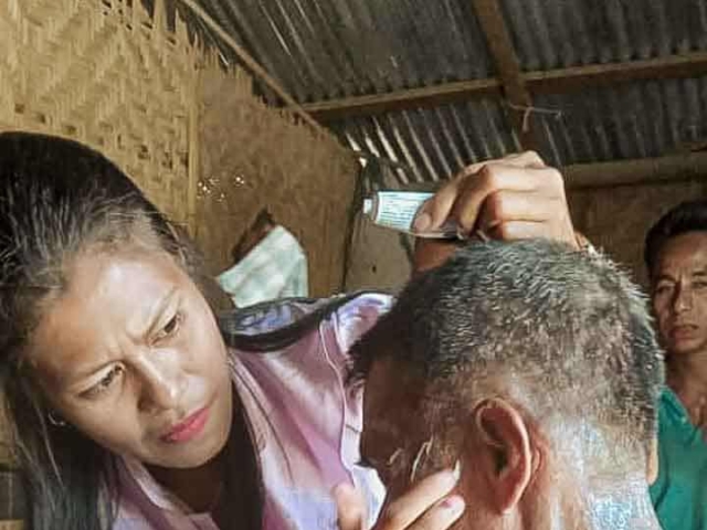 A health agent from Kawan Sehat is providing medical care to a patient in a remote village.