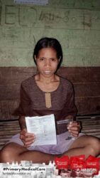 A health agent from Kawan Sehat is providing medical care to a patient in a remote village.