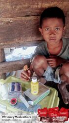 A health agent from Kawan Sehat is providing medical care to a patient in a remote village.