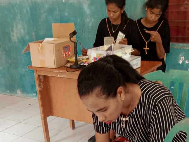 A health agent from Kawan Sehat is providing medical care to a patient in a remote village.