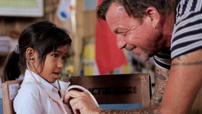 Young girl hearing her heartbeat for the first time with a stethoscope in a rural village.