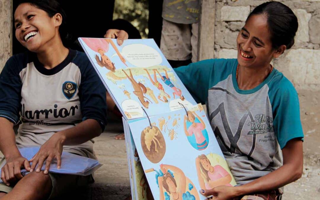 Women from rural villages reading the Kawan Sehat book and learning about healthy living.