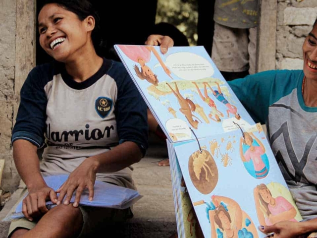 Women from rural villages reading the Kawan Sehat book and learning about healthy living.