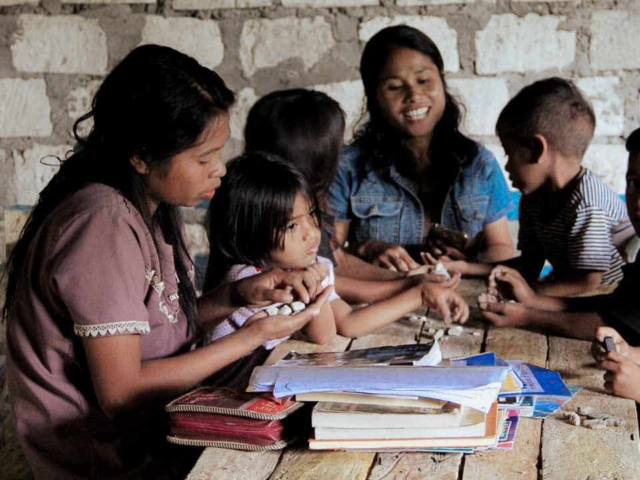 Children in a rural reading garden learning to read and write with donated educational materials.