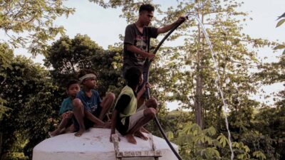 Children sitting on a reservoir in a rural village, celebrating the arrival of clean water.