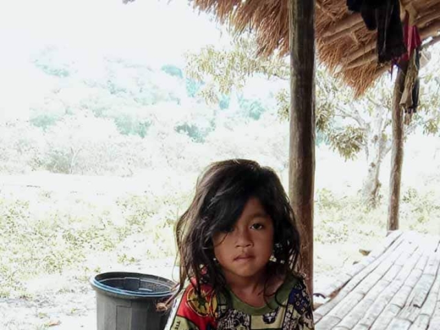 A health agent from Kawan Sehat is providing medical care to a patient in a remote village.