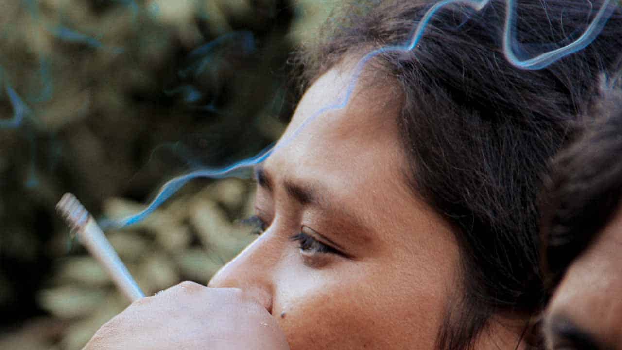 A mother and child exposed to secondhand smoke in a rural village emphasizing the dangers of passive smoke