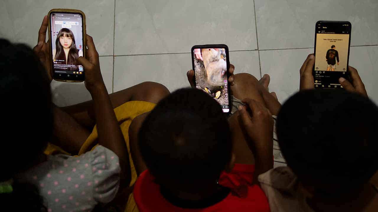 A child looking at a phone, symbolizing the risks of social media on mental health.