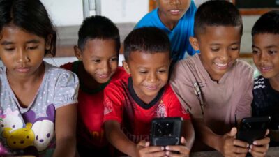 A child looking at a phone, symbolizing the risks of social media on mental health.