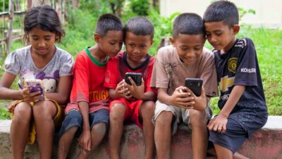 A child looking at a phone, symbolizing the risks of social media on mental health.