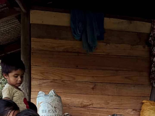 A health agent from Kawan Sehat is providing medical care to a patient in a remote village.