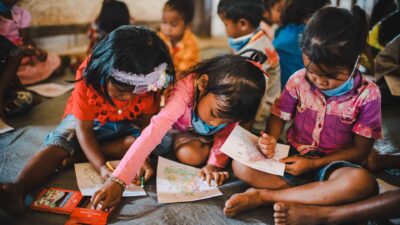 Les enfants dessinent et colorient ensemble sur le sol