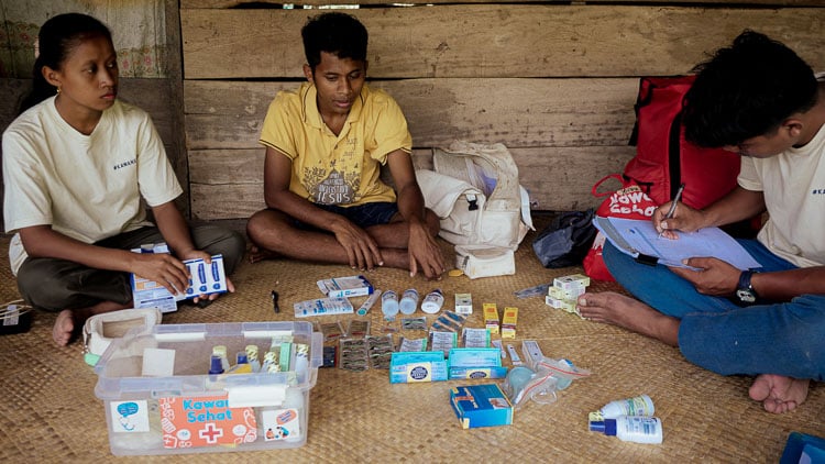 Anti-tobacco poster displayed in an Indonesian village, educating families about passive smoke dangers.