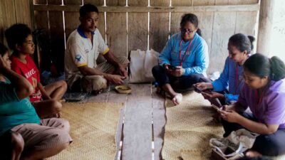 Photos of the Umalulu malaria baseline survey: children collecting water, health agents interviewing families, and distributing mosquito nets in rural East Sumba