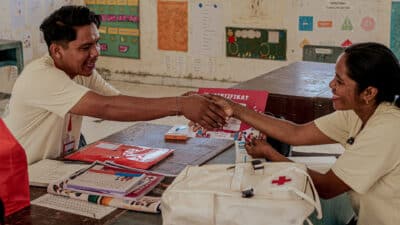 Un coordinateur de santé délivre un certificat à un agent de santé rural tout en vérifiant son approvisionnement en médicaments dans le Laindatang village.