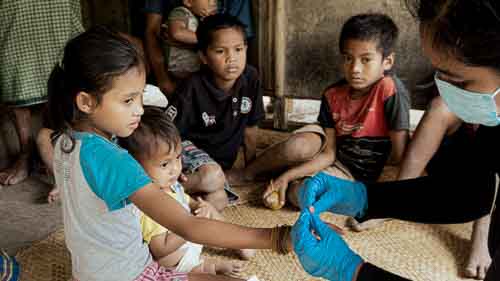 Women from rural villages reading the Kawan Sehat book and learning about healthy living.