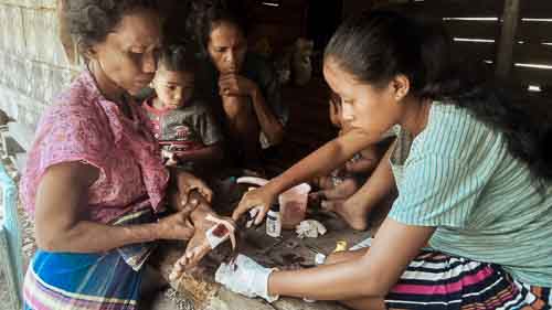 Women from rural villages reading the Kawan Sehat book and learning about healthy living.