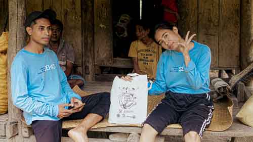 Women from rural villages reading the Kawan Sehat book and learning about healthy living.