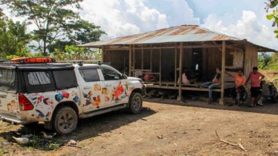Photos showing difficult road access in East Sumba: trucks stuck in mud, crossing rivers, or navigating steep rocky tracks to deliver humanitarian aid