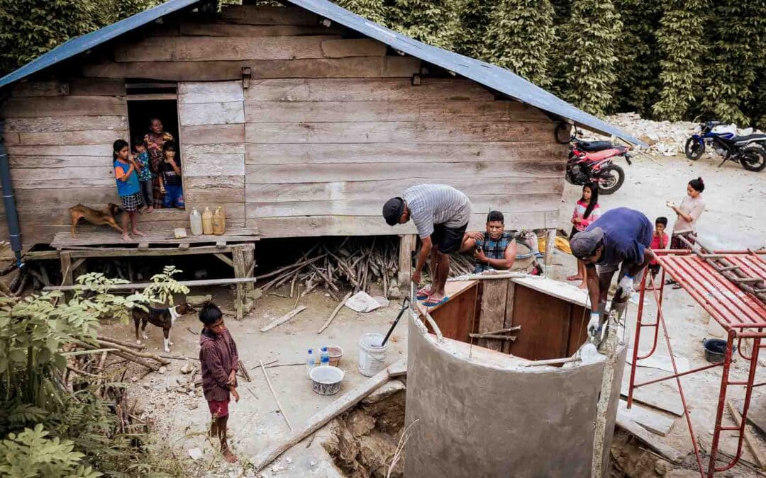 Family in Soumbayes assisting in the construction of a 5,300-liter ferrocement water tank next to their wooden house