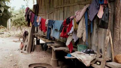 Clothes hanging outside a wooden house in Umalulu, attracting mosquitoes.