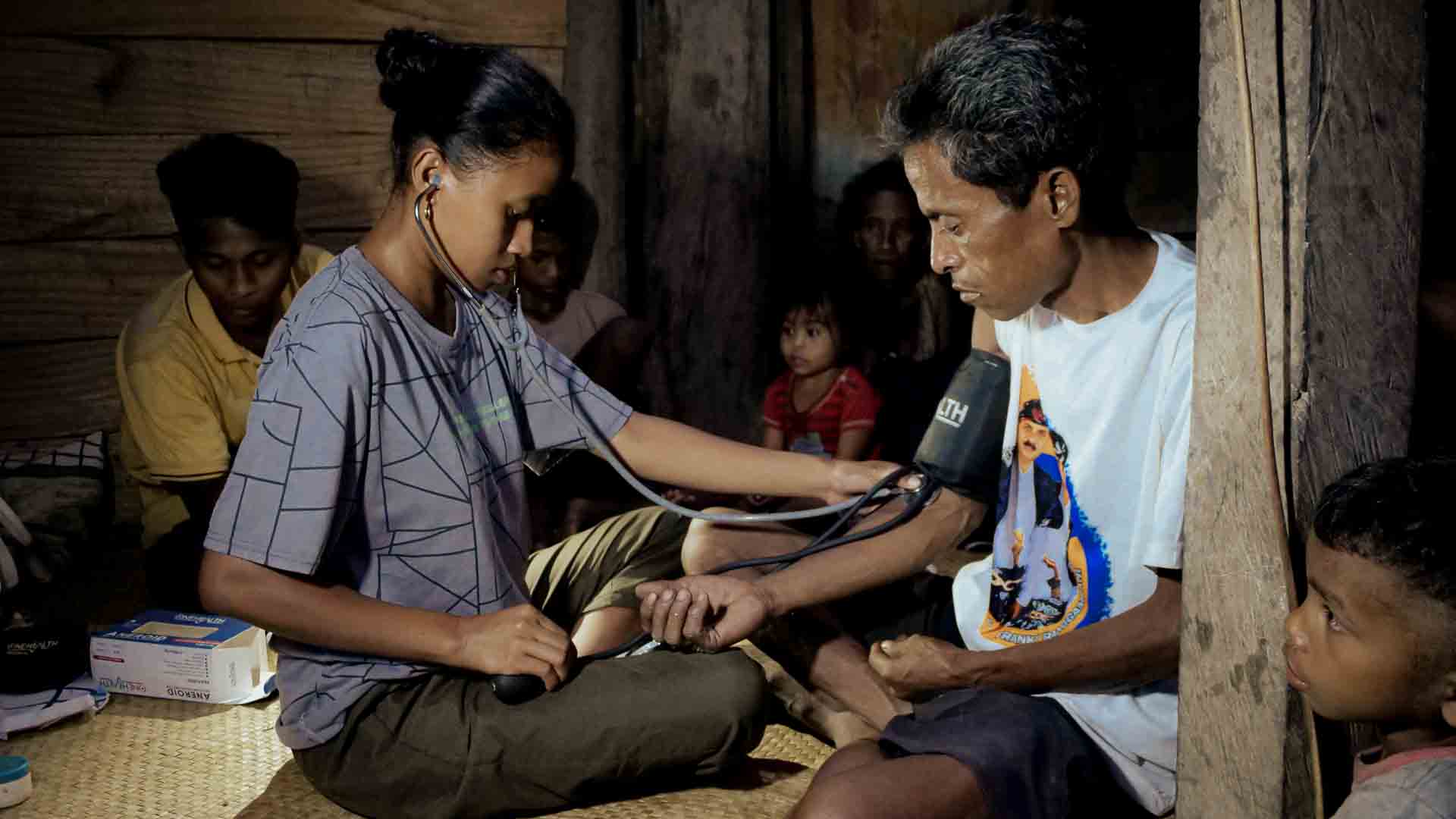 Female health agent caring for a patient in rural Sumba