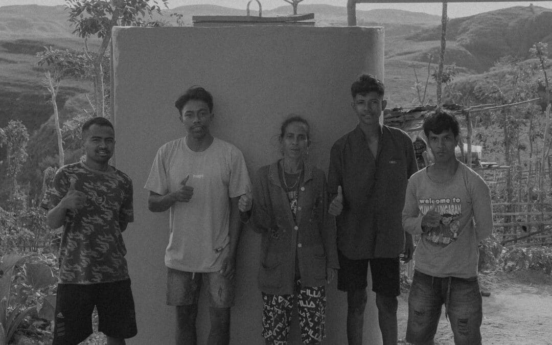 Caretaker opens lockable hatch of ferrocement rainwater tank in Hambarita