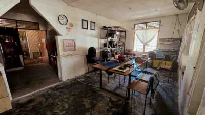 Petit bureau vétuste à Rumah Kambera, avec tables, chaises, étagères chargées de matériel et sol très abîmé, où l’équipe de Fair Future organise ses missions.