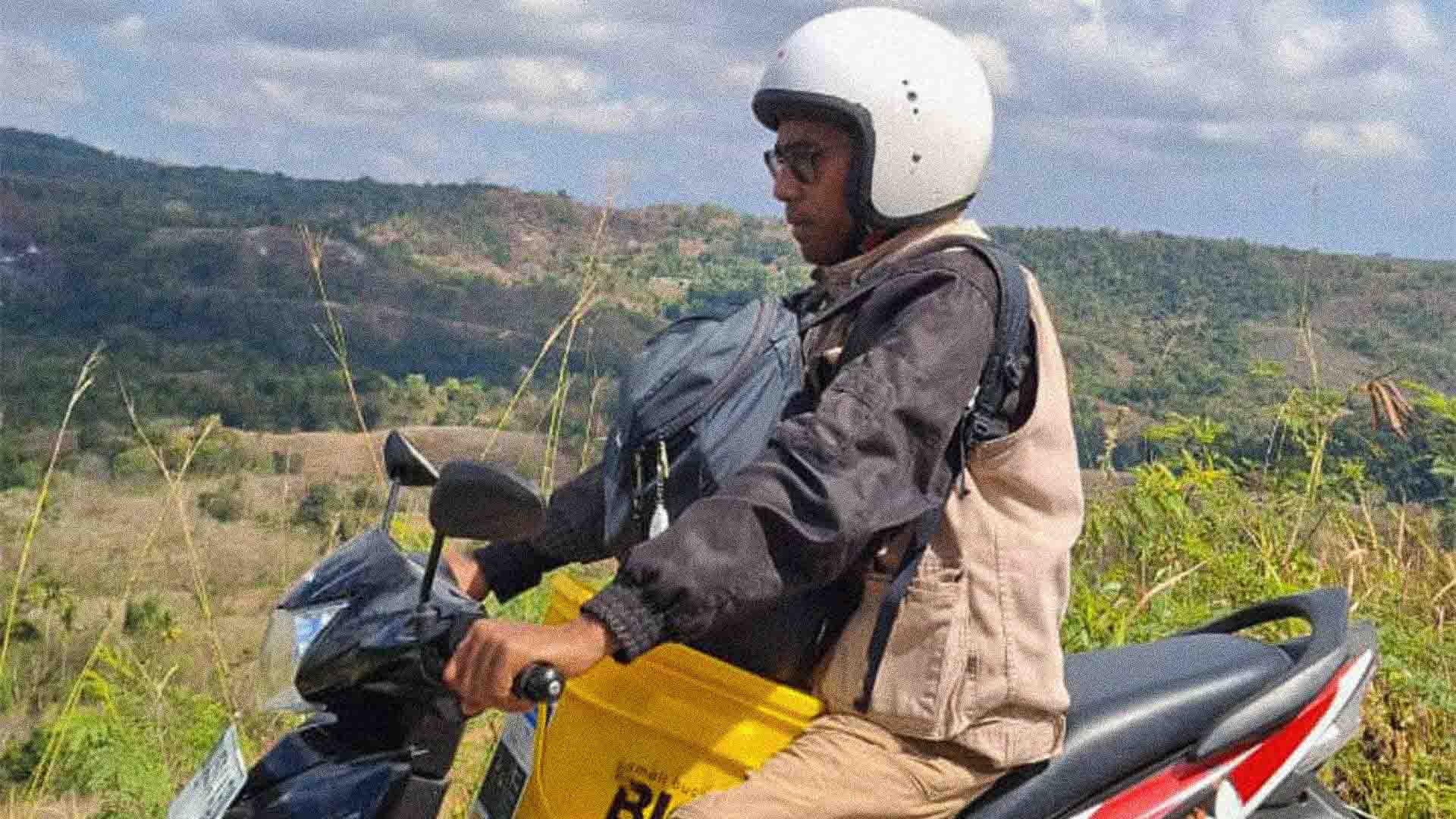 Girl in Lapinu holding a SolarBuddy lamp that replaces smoke and gives clean study light in a remote East Sumba village.