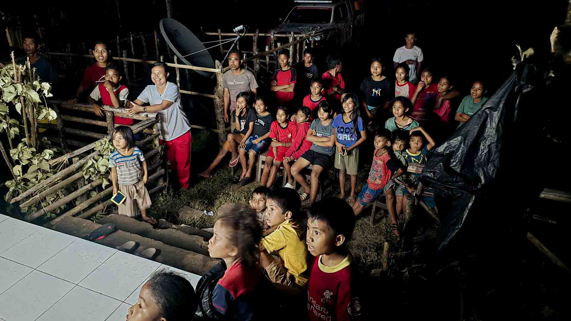 The First Movie Night with Electricity in Mbajik Children and villagers in Mbajik watching a film at night, powered by solar electricity installed at their school for the first time.