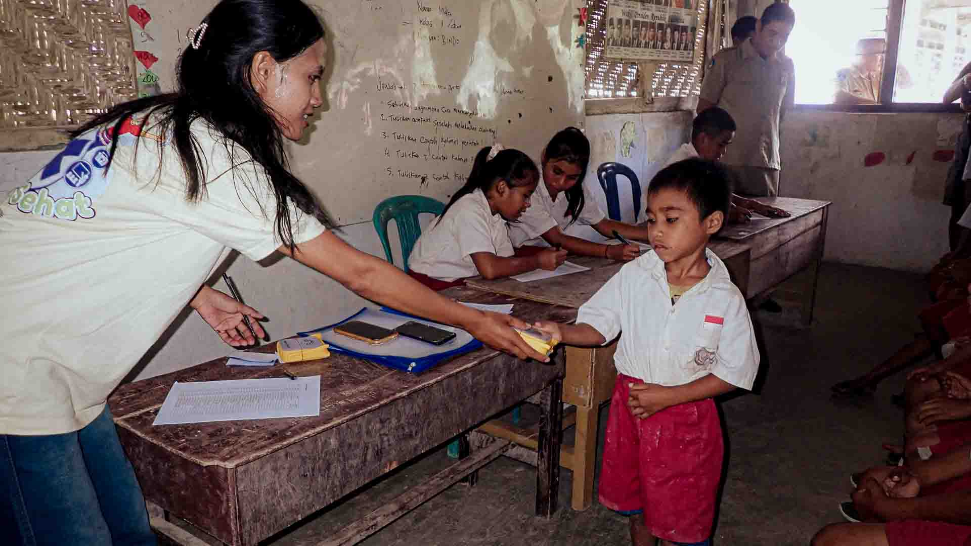 A Handful of Light in an Ultra-Rural Classroom of East Sumba A Fair Future collaborator hands a SolarBuddy lamp to a young student inside an ultra-rural school classroom in East Sumba, Indonesia.