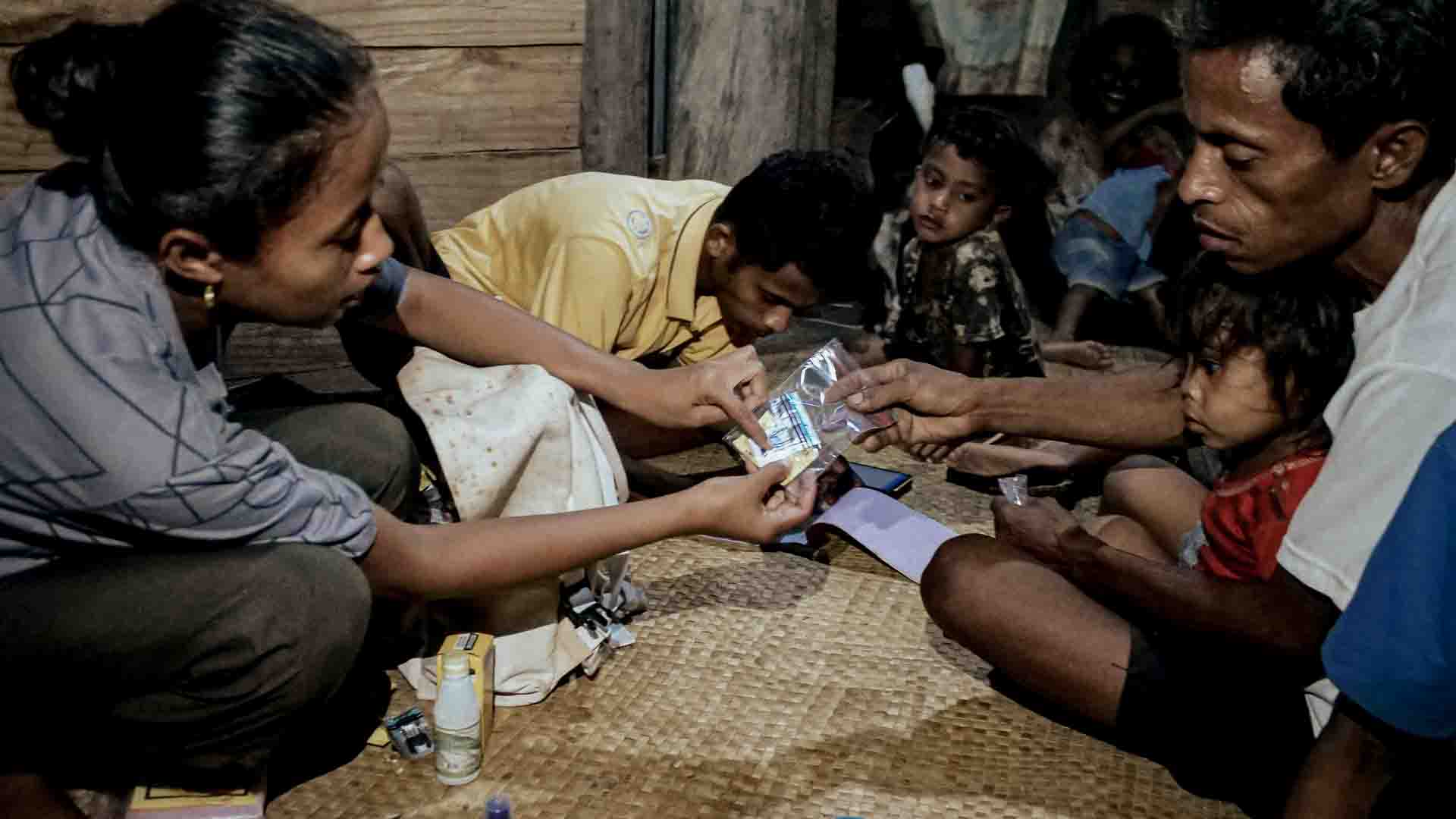 Community Health Broker delivering primary medical care during home visit in East Sumba village.