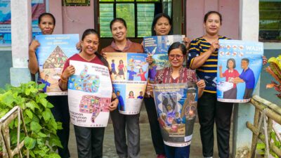Teachers holding school health posters in rural Indonesia